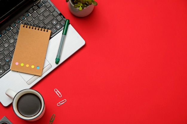 Mesa plana moderna espaço de trabalho vermelho lay com laptop, óculos, smartphone, xícara de café.