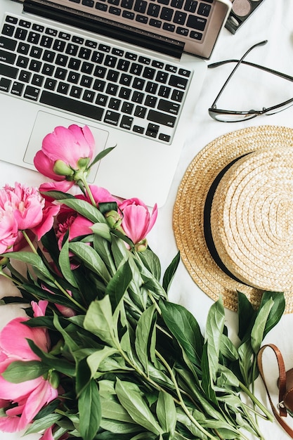 Mesa plana, vista de cima, moda feminina, mesa de escritório com flores peônia, laptop na superfície branca