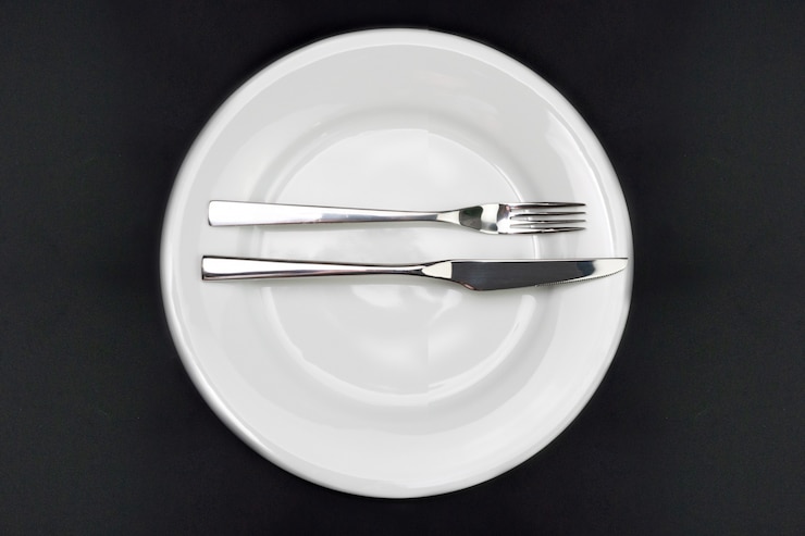 Foto mesa, plato vacío, cuchillo y tenedor en negro