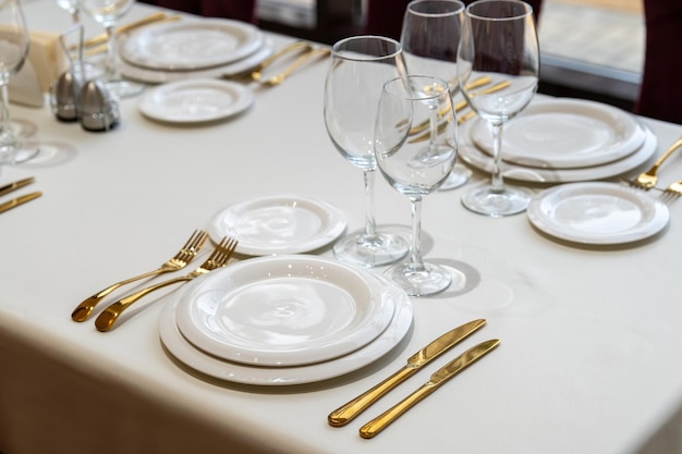 mesa de platos blancos con platos vacíos Preparación de restaurante de lujo para la celebración