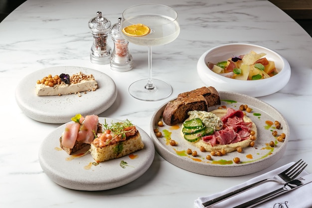 Una mesa con platos de comida incluyendo comida y bebida.