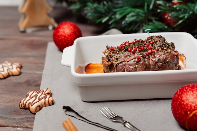 Mesa con platos navideños Carne de res horneada o asada con especias carne tierna Confección de la mesa Cena familiar de Navidad