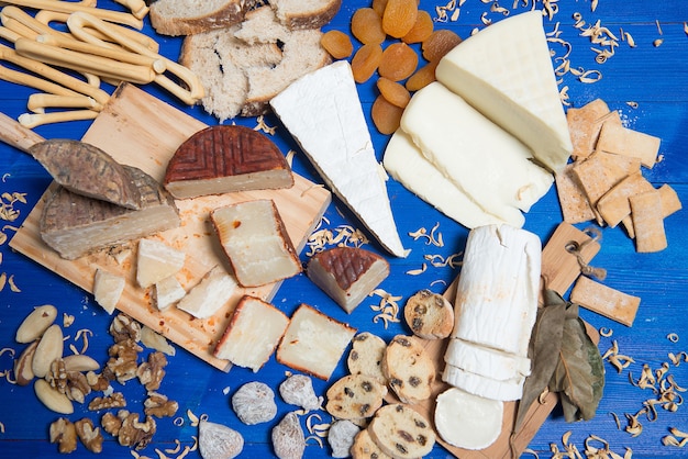 mesa posta com tábua de queijos e diferentes tipos de pão