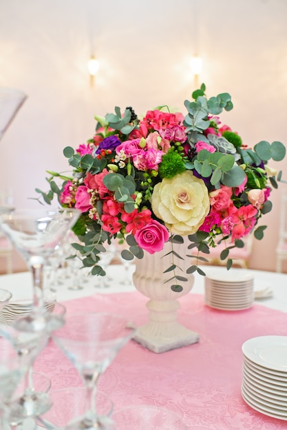 Mesa posta no banquete de casamento no restaurante, estilo clássico com toalhas de mesa e guardanapos brancos, vasos com flores.