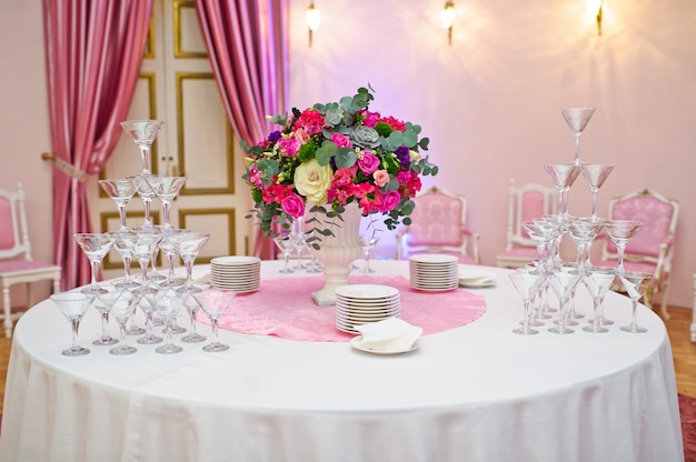 Mesa posta no banquete de casamento no restaurante, estilo clássico com toalhas de mesa e guardanapos brancos, vasos com flores.