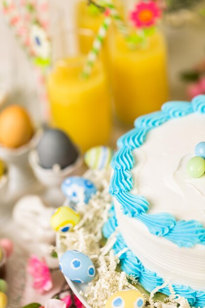 Mesa de postres con pastel y cupcakes para el brunch de Pascua.