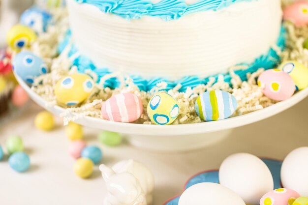 Mesa de postres con pastel y cupcakes para el brunch de Pascua.