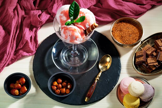 Una mesa con postres y un plato de helado con un paño rojo encima.