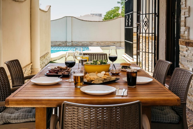 Mesa puesta para un almuerzo con amigos en una casa con piscina