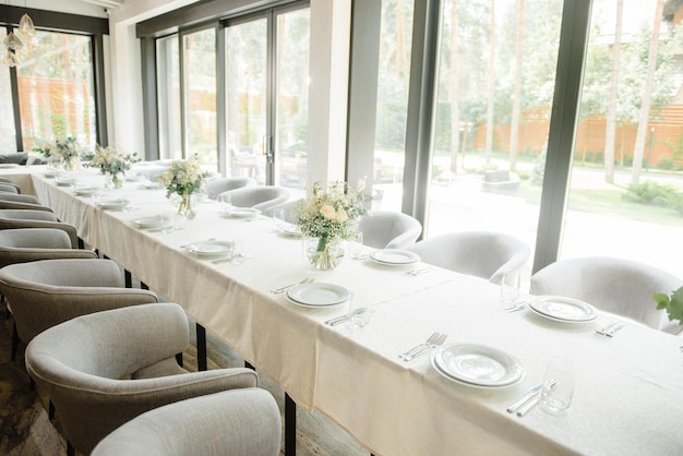 Mesa de recepción de bodas en el restaurante decorada con velas blancas y flores.
