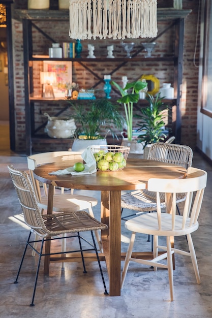 Mesa redonda de madera de estilo rústico en el comedor con una cesta de limones