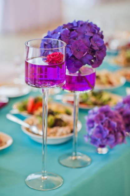 Mesa en el restaurante decorada con flores moradas, cena de bodas.