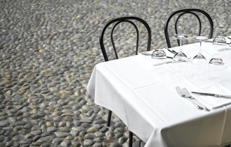 Mesa de restaurante elegante en la terraza y fondo de calle de piedra gris rústico