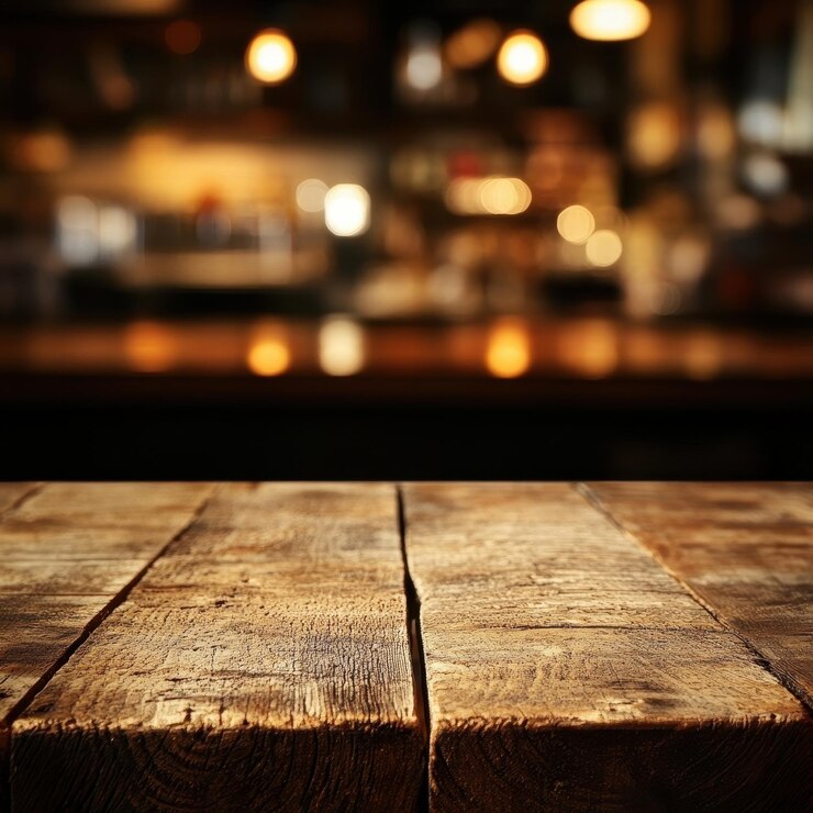 Una mesa de restaurante de madera rústica crea una atmósfera cálida y acogedora perfecta para experiencias gastronómicas el fondo borroso agrega un ambiente acogedor al entorno