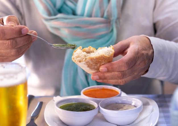 En la mesa del restaurante una mujer degusta una de las salsas típicas de Canarias, llamada "mojo"