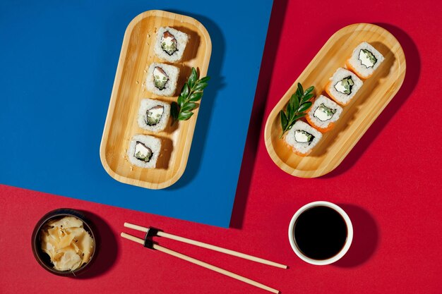 Una mesa roja y azul con sushi y palillos