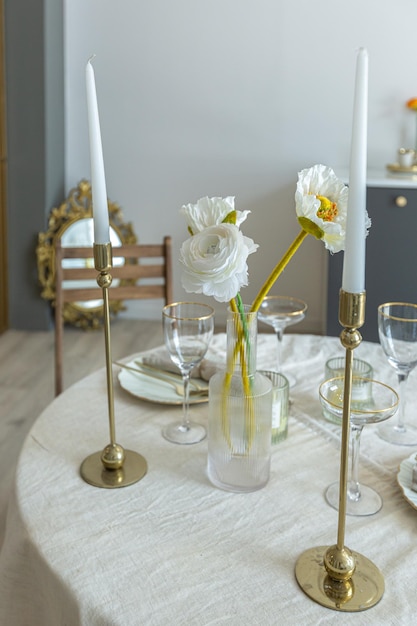 Foto mesa romântica é servida para dois na cozinha em um apartamento de plano aberto brilhante em estilo moderno com paredes leves e pisos de madeira