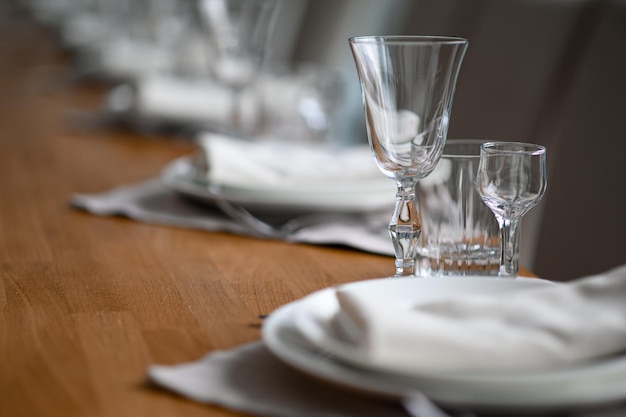 Mesa romántica festiva con servilleta gris plateada y vajilla blanca sobre mantel de seda beige