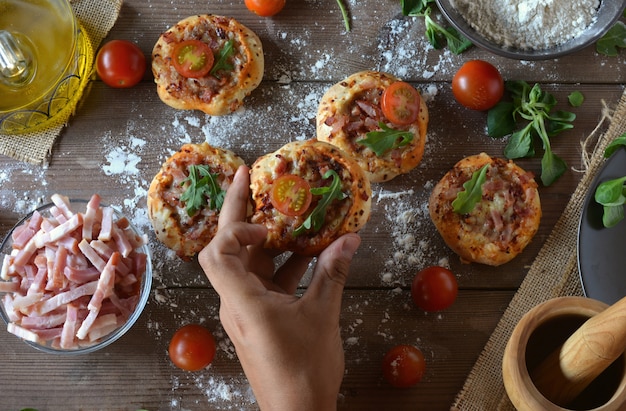 Mesa rústica con mini pizzas de tocino.