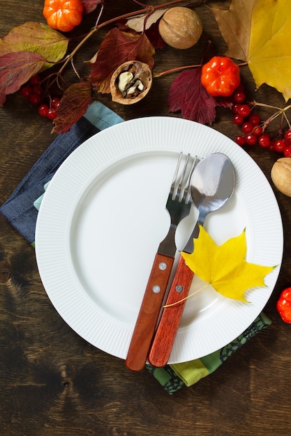 Mesa rústica de otoño de Acción de Gracias o ajuste de la tabla de cosecha de otoño con plata rústica sobre una mesa