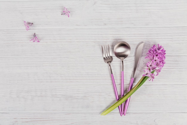 Mesa rústica rosa com flor de jacinto roxo e guardanapo de linho na mesa de madeira branca