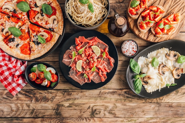 Mesa con sabrosas comidas italianas en platos