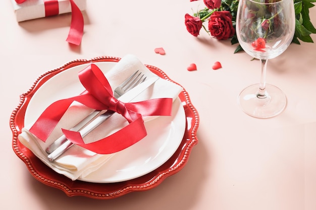 Mesa de San Valentín con decoración roja, regalos y rosas.
