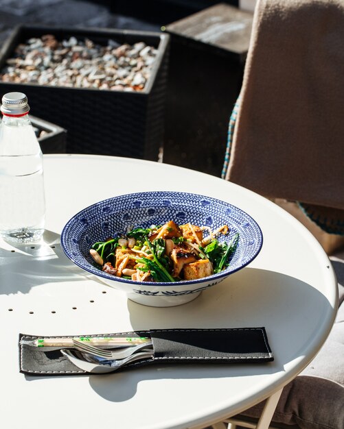 Mesa servida com prato de tofu frito com espinafre e nozes