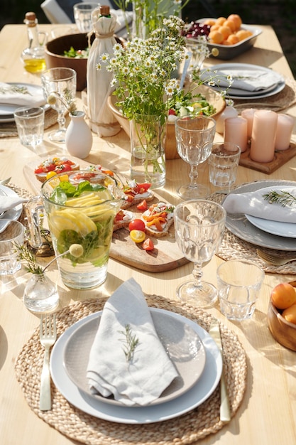 Mesa servida com pratos de copos de bebidas de comida caseira e velas