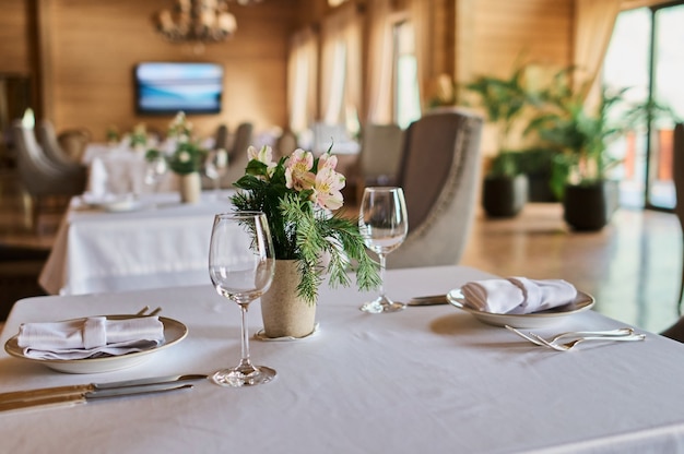 Mesa servida com velas acesas e flores frescas para um jantar festivo.