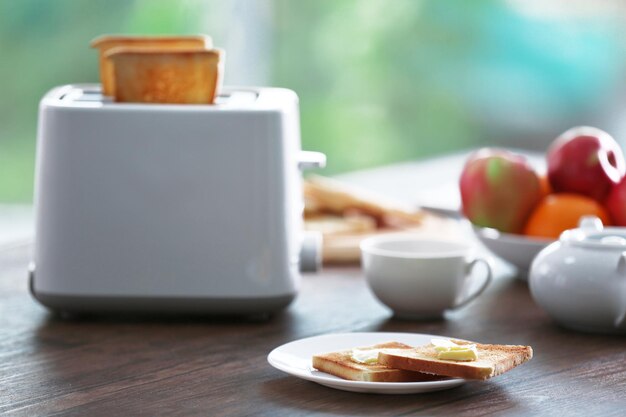 Foto mesa servida para el desayuno con café tostado y fruta en un fondo borroso