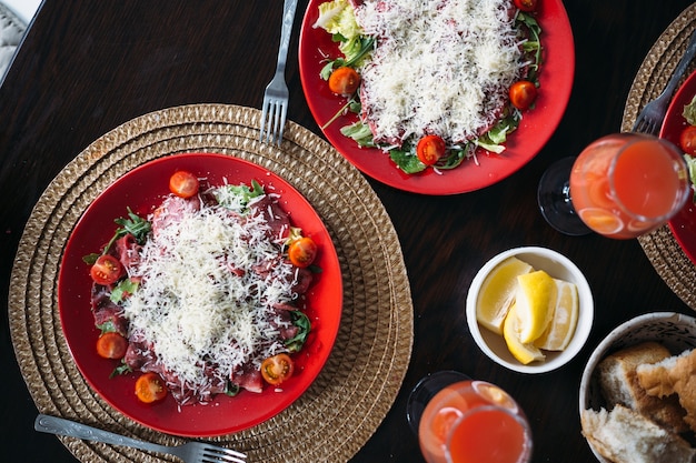 Foto mesa servida em casa com suco de pão fresco de carpaccio italiano caseiro