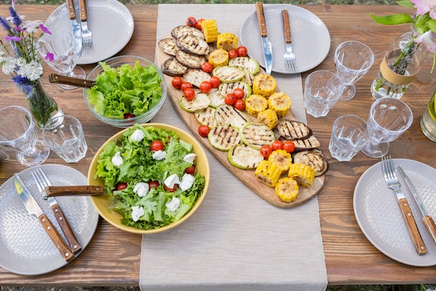 Mesa servida con platos y vasos de comida vegetariana