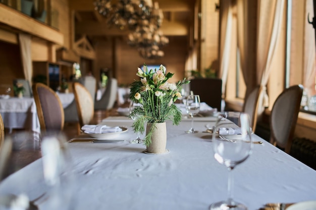 Mesa servida con velas encendidas y flores frescas para una cena festiva.