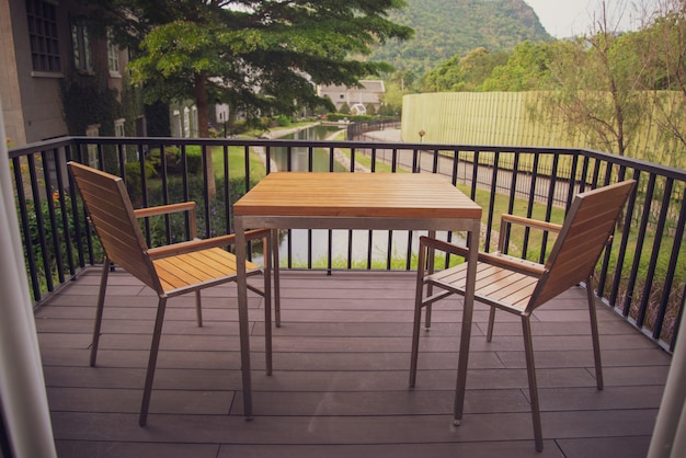 Mesa y silla de madera en el balcón de la casa.