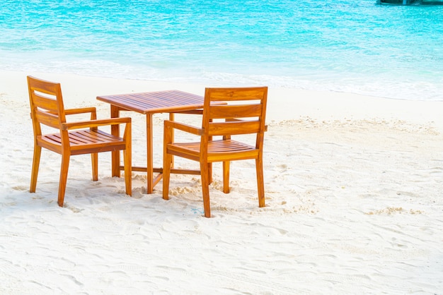 Mesa y silla de madera en la playa con vista al mar en Maldivas