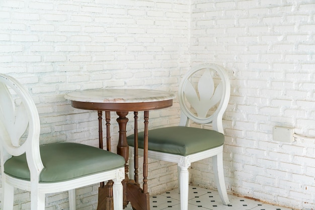 mesa y silla vintage con pared de ladrillo blanco