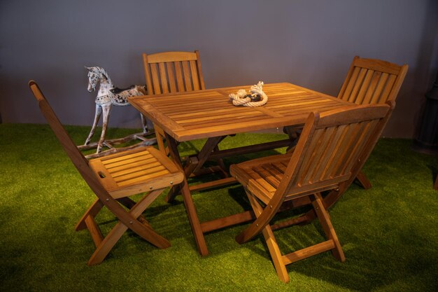 Una mesa y sillas de madera con un caballo al lado.