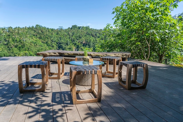 Mesa y sillas de madera en un café tropical vacío junto a terrazas de arroz en la isla Bali Indonesia