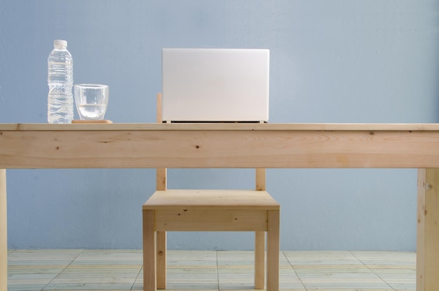 Mesa y sillas de madera contra la pared