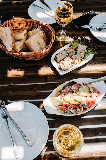 Una mesa con sol con cubiertos, comida, vino para que dos personas celebren Concepto de almuerzo para cenar Concepto de almuerzo de negocios vista plana superior