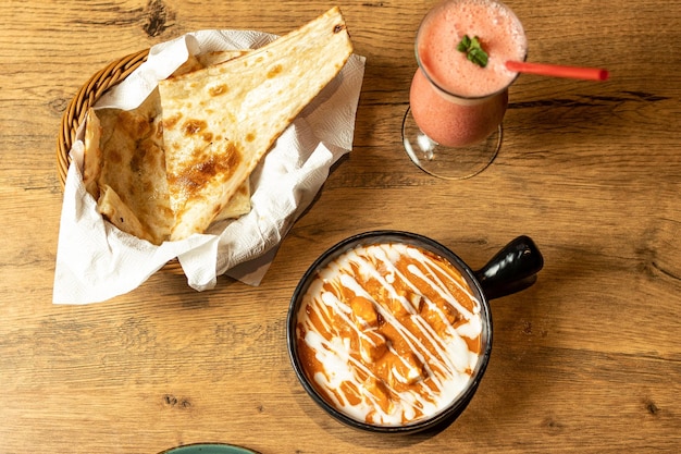 Una mesa con una taza de café y un pan de pita.