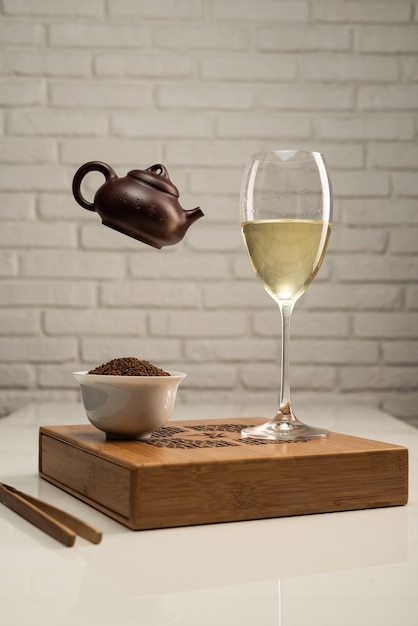 Mesa de té con electrodomésticos y una copa de vino en la que se prepara el té