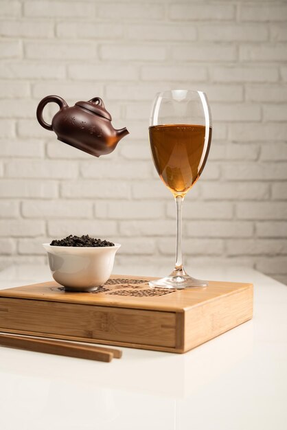 Mesa de té con electrodomésticos y una copa de vino en la que se prepara el té