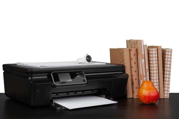 Mesa de trabajo con impresora y libros apilados en abckground blanco