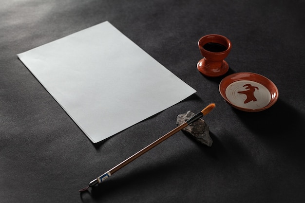 Mesa de trabajo maestra de caligrafía con papel y bolígrafo