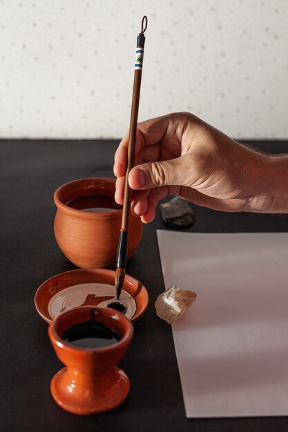 Mesa de trabajo maestra de caligrafía con papel y bolígrafo