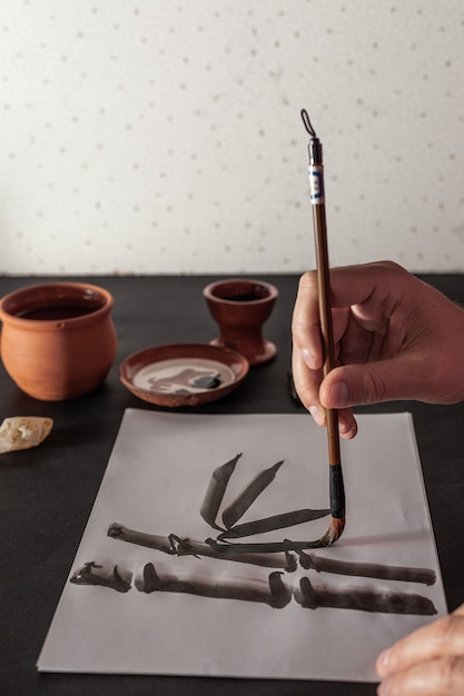 Mesa de trabajo maestra de caligrafía con papel y bolígrafo