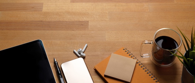 Foto mesa de trabajo de moda con espacio de copia, maqueta de teléfono inteligente, tableta, taza de café y papelería