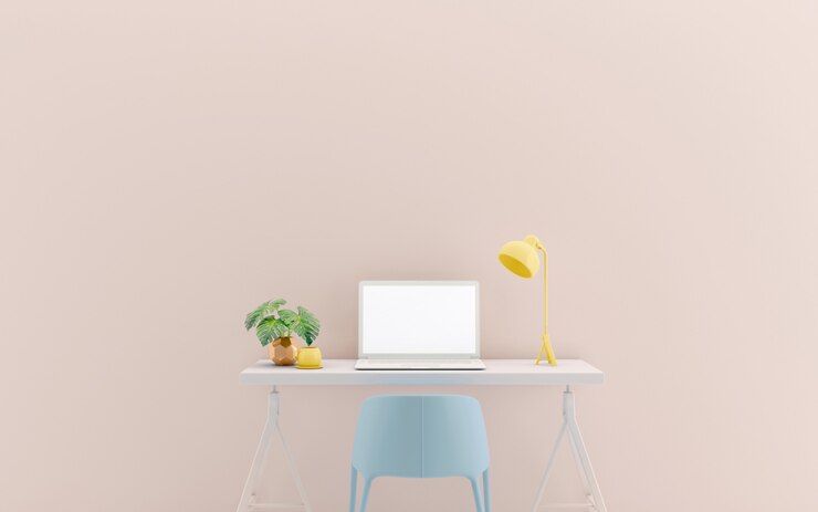 Mesa de trabajo con ordenador portátil contra la pared colorida